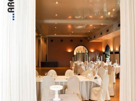Interieur feestzaal Salons Montovani met witte tafels en witte stoelen